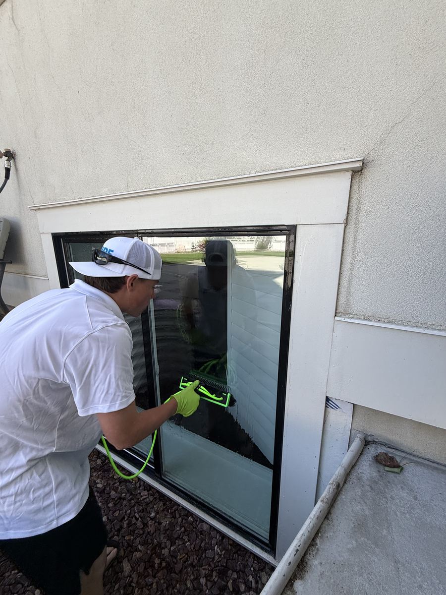 Close-up of window cleaning on a stucco home, pure water system in use